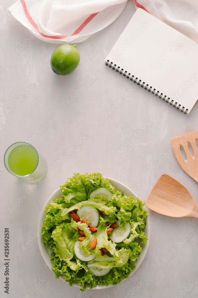 Fresh salad with tomatoes, cucumbers and lettuce on a wooden background