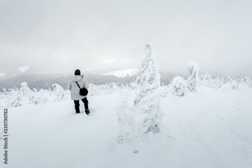 冬天独自一人背着背包在暴风雪中山顶拍摄。旅行理念。鲤鱼