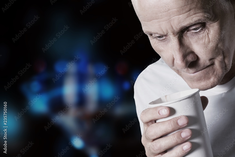 Thoughtful senior man holding white cup at home