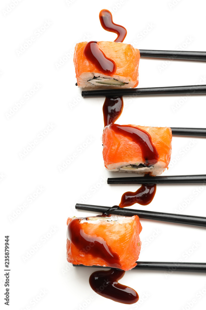 Tasty sushi rolls with chopsticks on white background