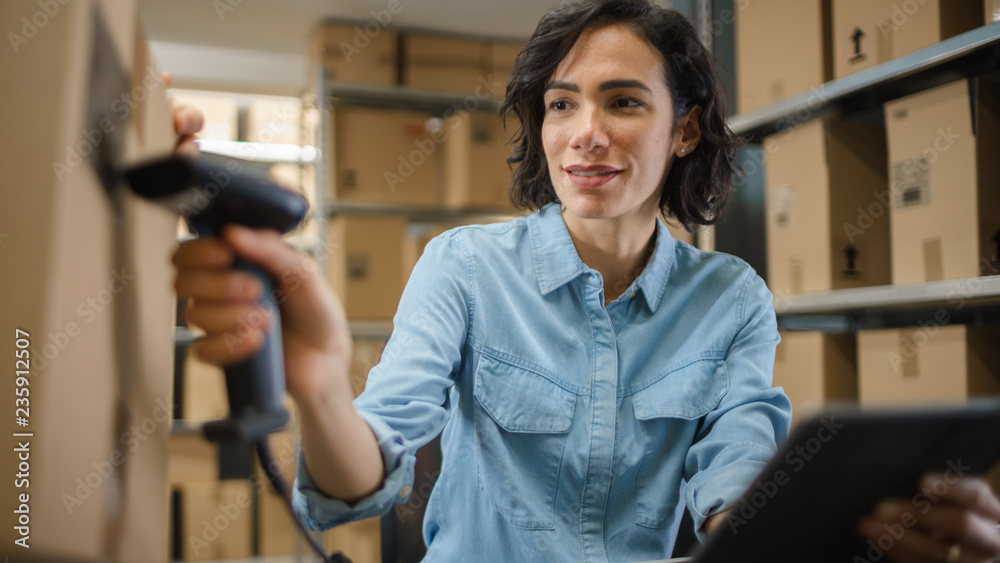 Female Inventory Manager Scans Cardboard Box and with Barcode Scanner. In the Background Rows of Car