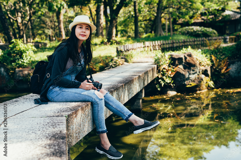 年轻的女性旅行者在日本花园里放松。