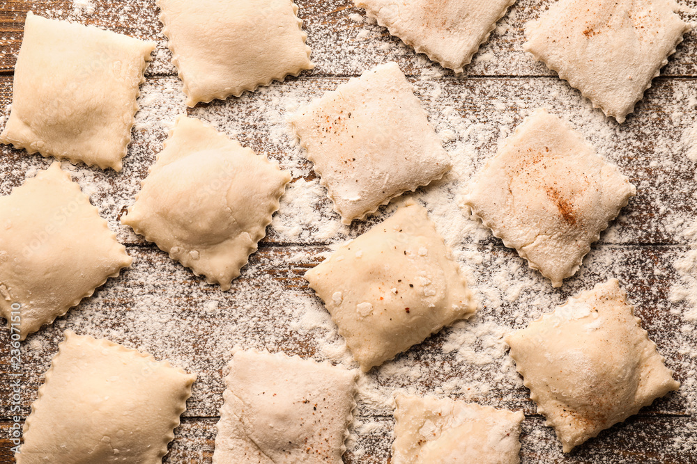 Tasty ravioli on wooden table, top view