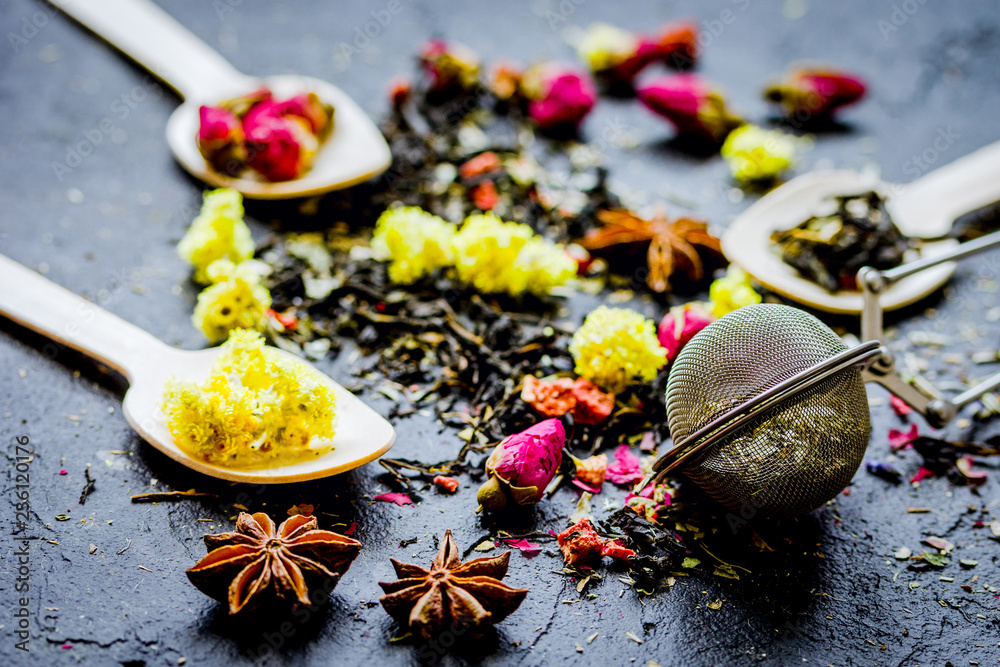 Tea herbs and spoons on grey background