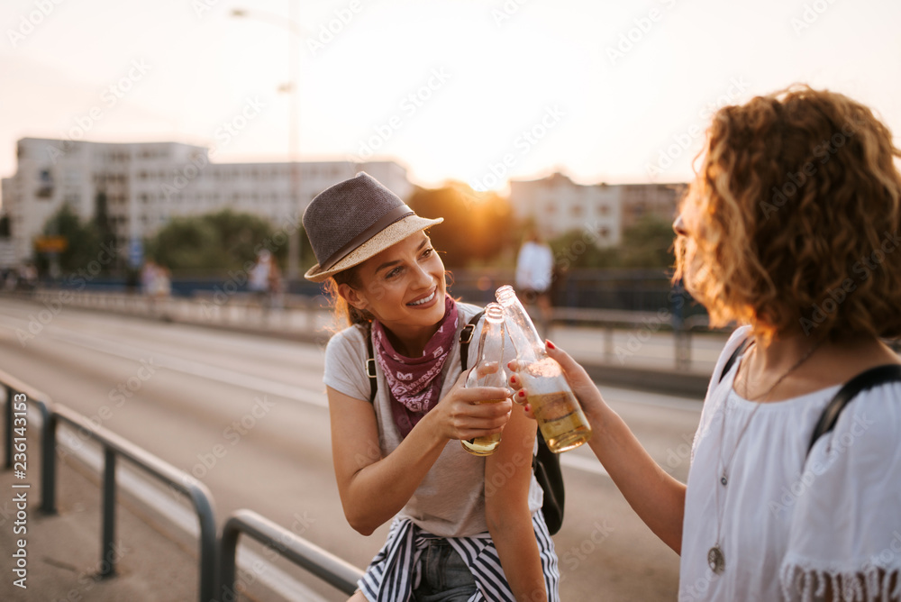 干杯！两个时尚的节日派对女孩在城市里举杯。