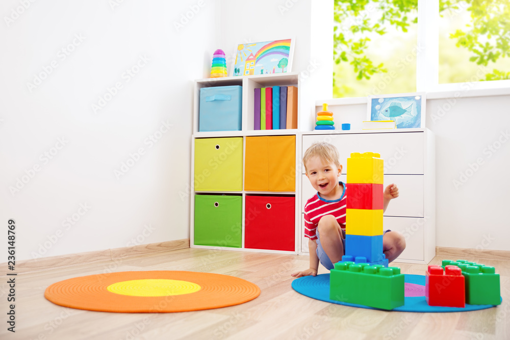 three years old child sitting on the floor with cubes