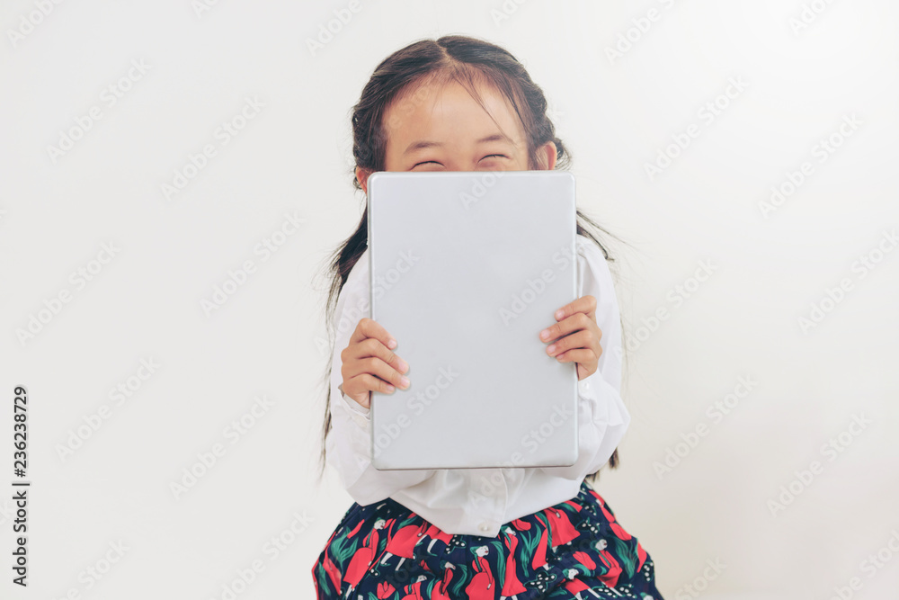 Little happy kid on white background with tablet computer. Childhood lifestyle.