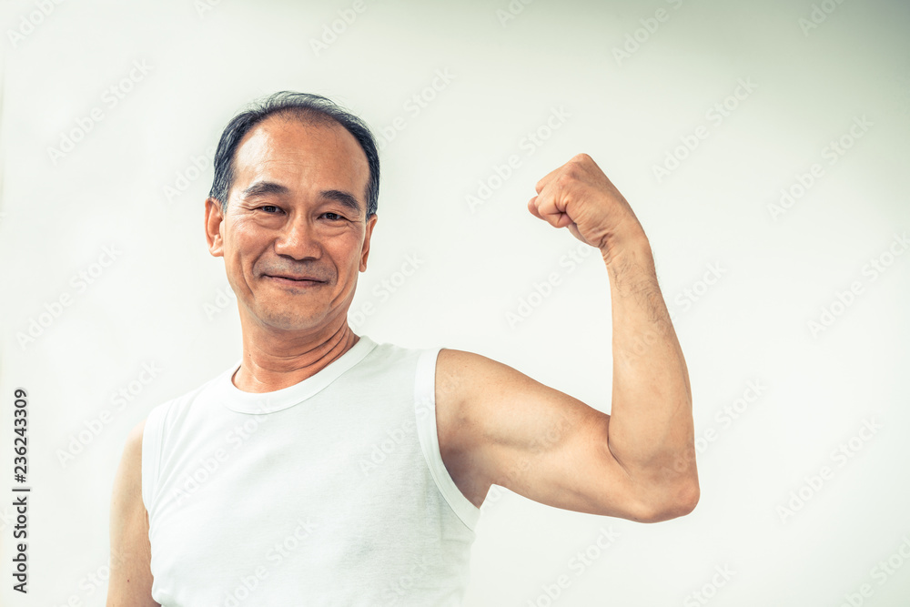 Strong healthy senior grandfather in gym fitness center. Happy retirement lifestyle.