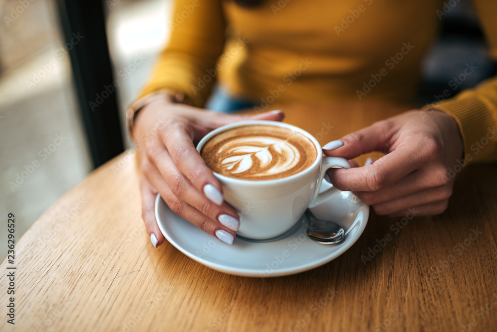 Drinking coffee in the cafe. Close-up.