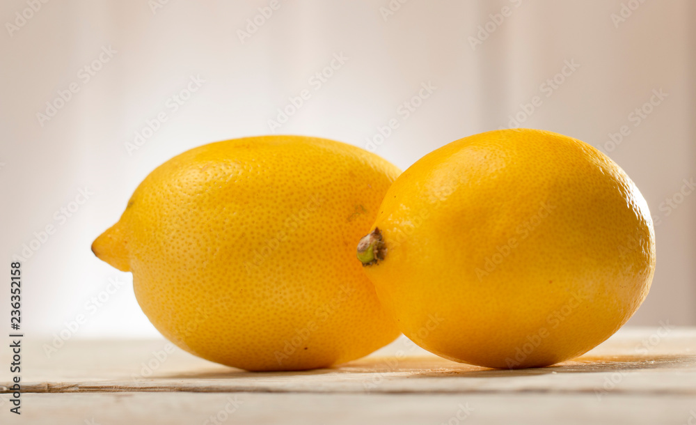 two Lemon on white wooden table close-up