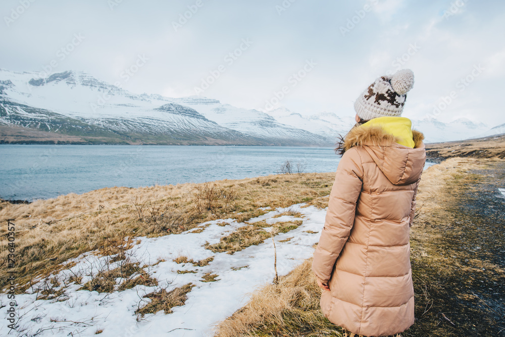 年轻的旅游女性惊叹并欣赏冰原白雪皑皑的山脉的美丽景观