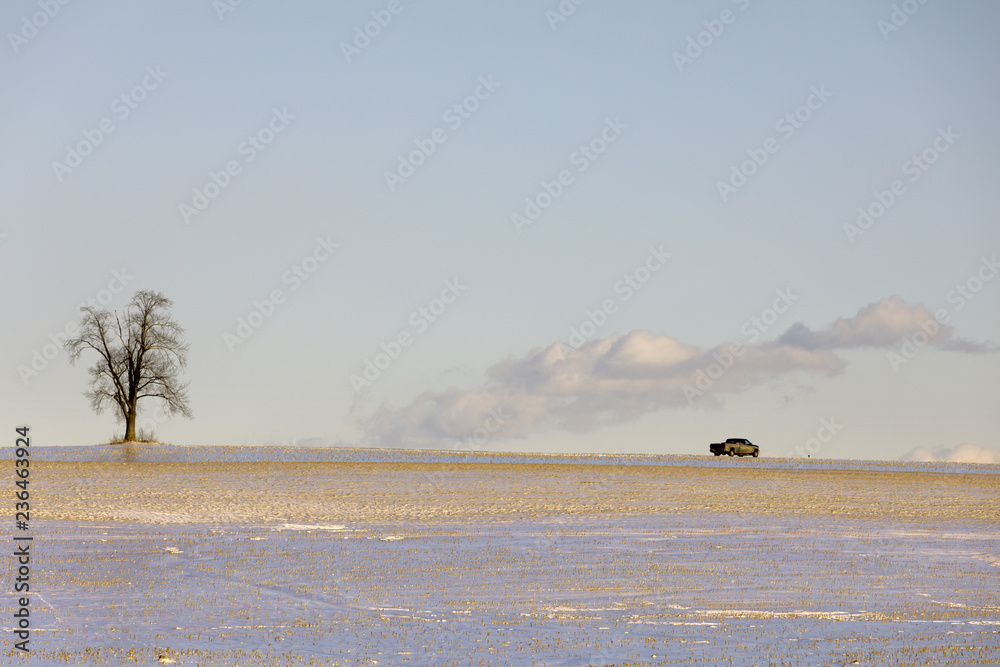 A pickup truck drives on a snow covered country road, Mohawk Valley, upstate New York, USA.