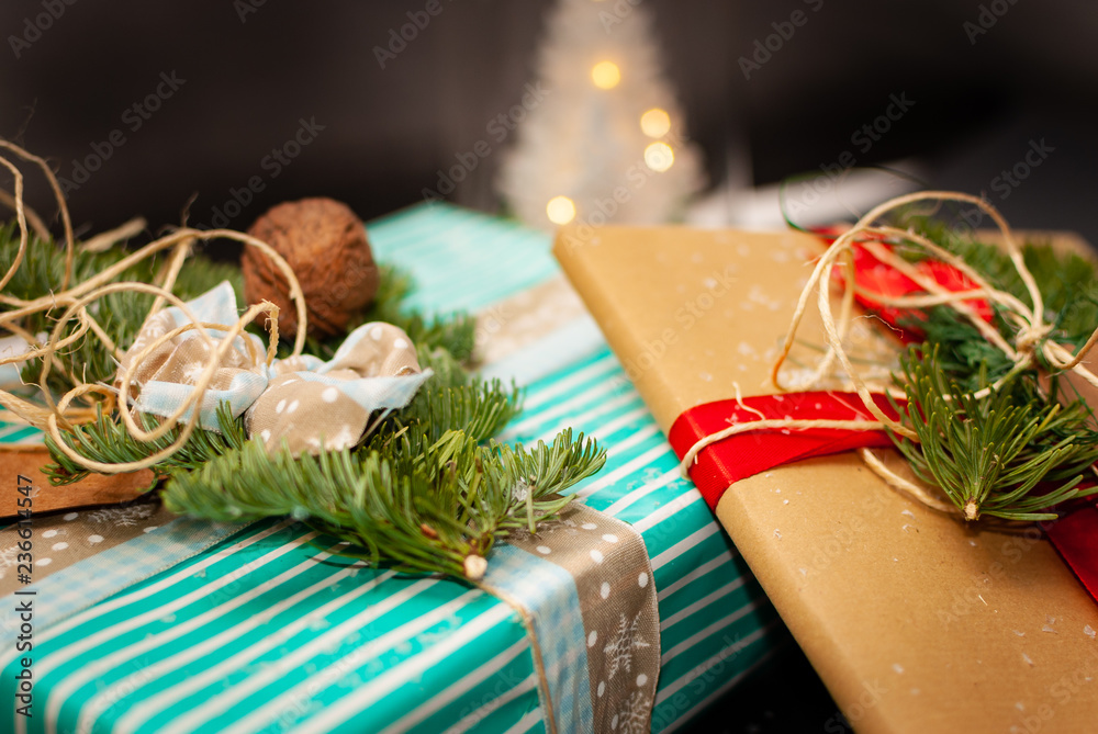 Flat-lay of two Christmas presents with some snow flakes, nuts, stars, a Christmas hut and a illumin