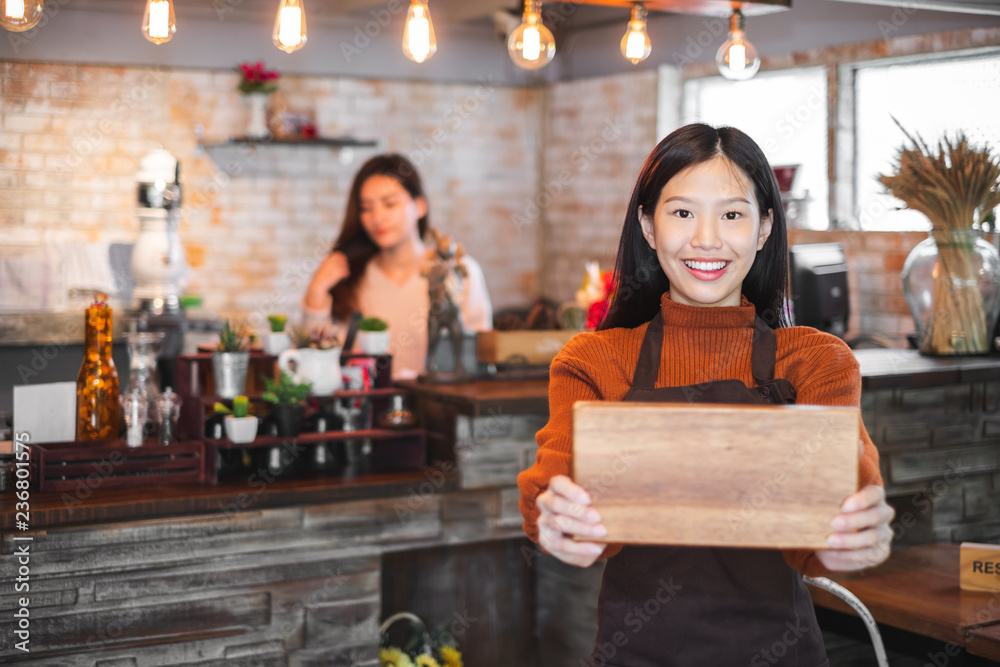 咖啡馆/酒吧/餐厅/咖啡和面包店前的年轻亚洲女性企业主