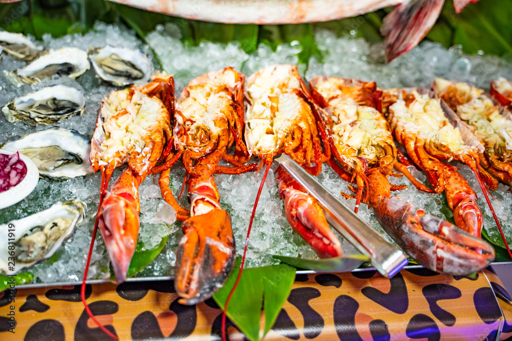 A close view of lobsters and oysters on ice. An exotic meal of tasty cooked lobsters. Close-up.