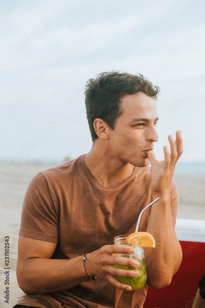 一名男子在海滩派对上喝莫吉托