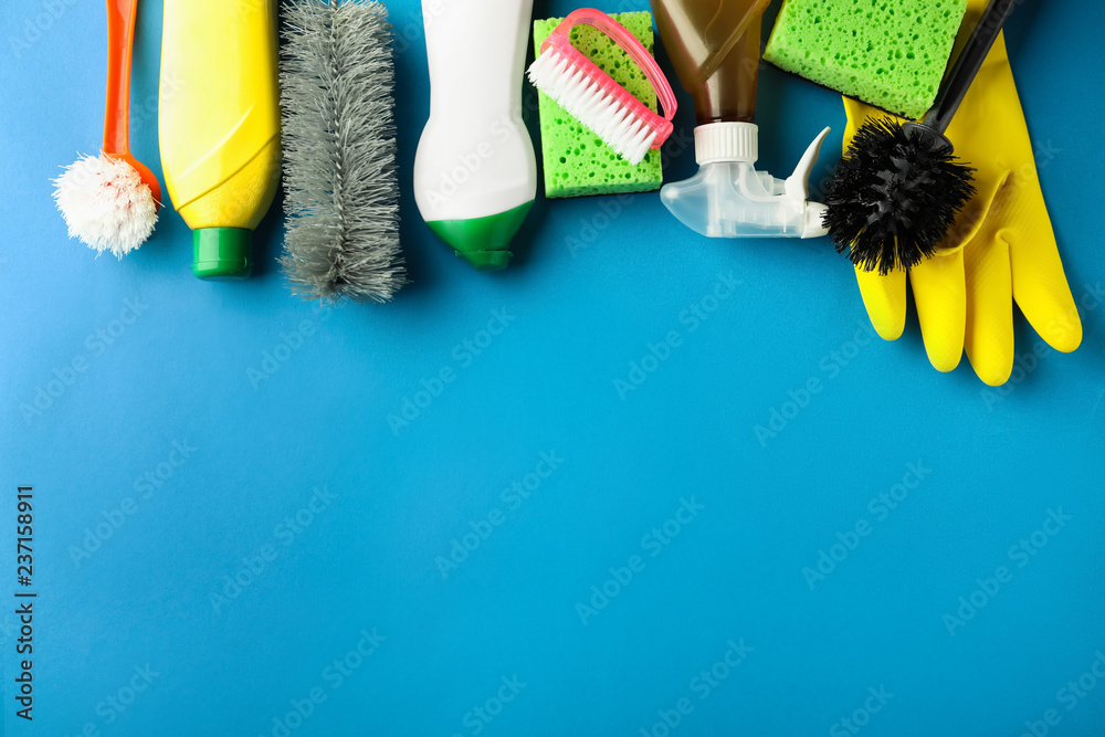 Flat lay composition with cleaning supplies on color background