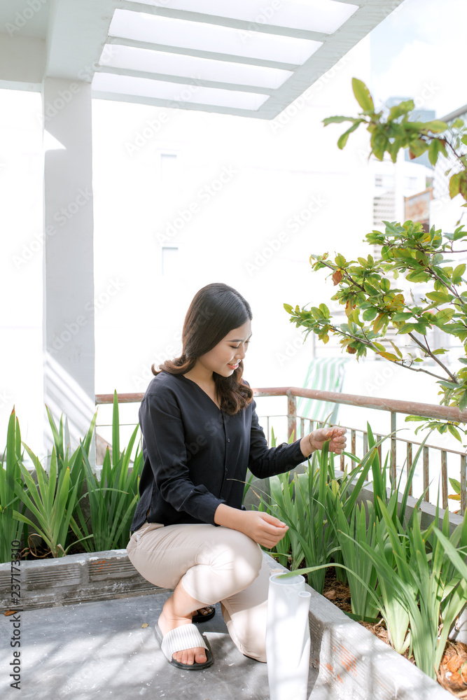 美丽的年轻女子在夏季户外园艺