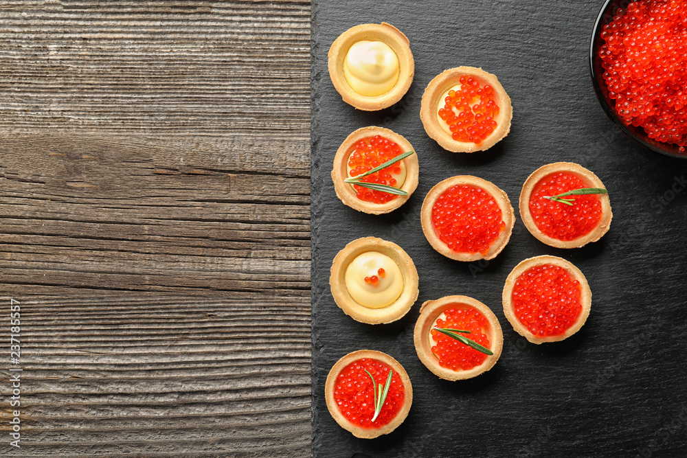 Delicious canapes with red caviar on slate plate