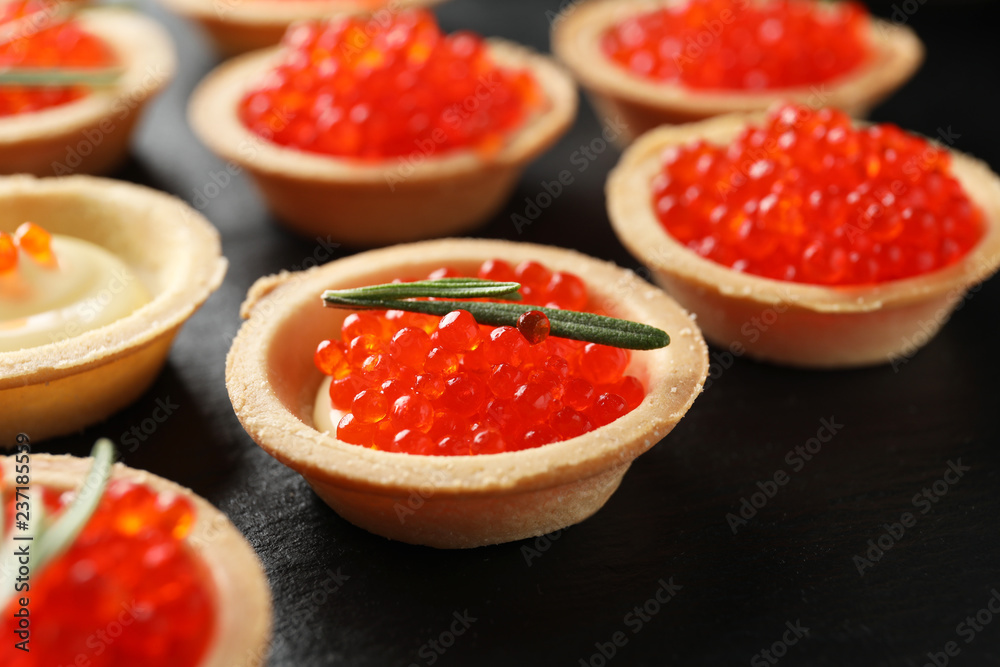 Delicious canapes with red caviar on slate plate, closeup