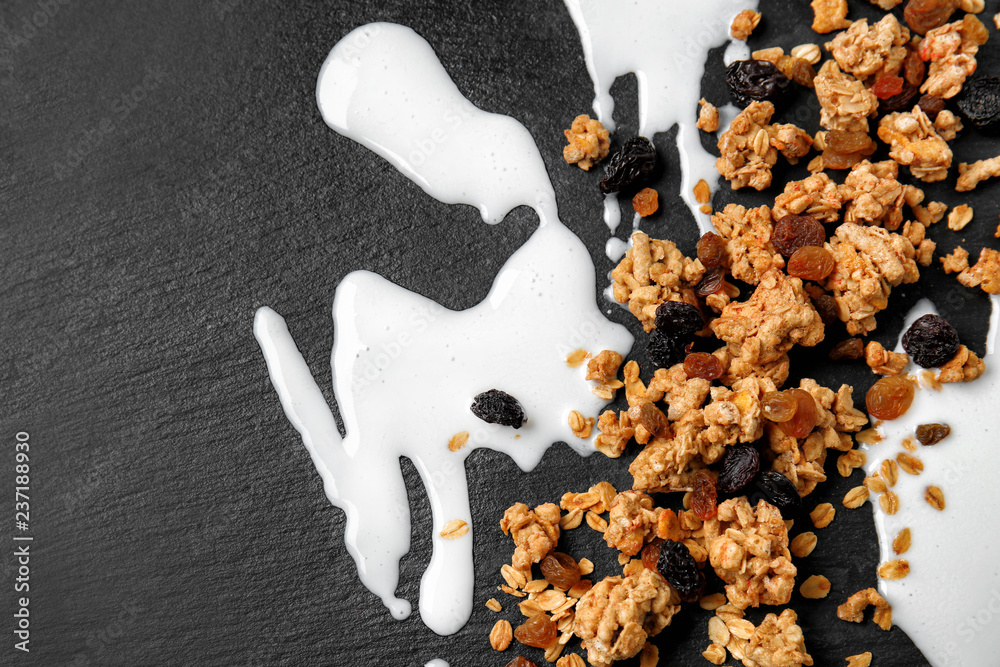 Granola with raisins and milk stains on dark background