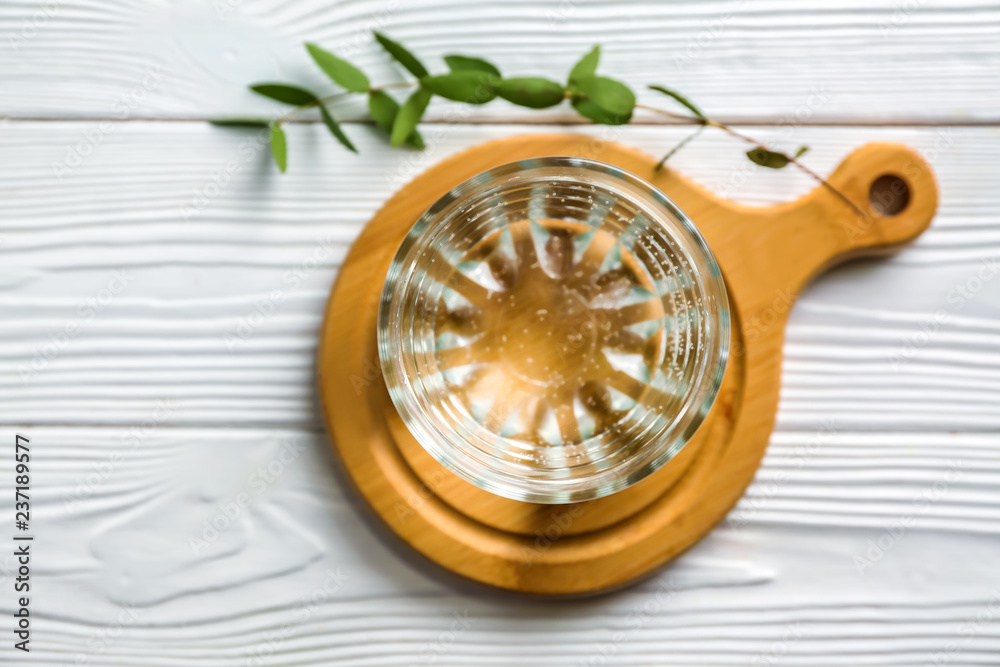 Glass of fresh water on wooden board