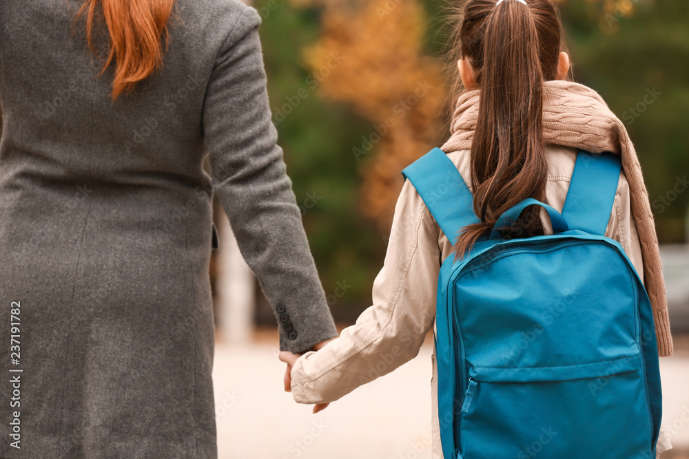 可爱的女孩在户外和妈妈一起上学