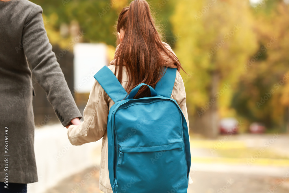 可爱的女孩在户外和妈妈一起上学