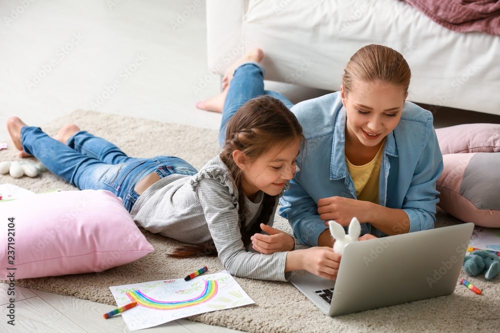 Cute girl with mother doing homework at home