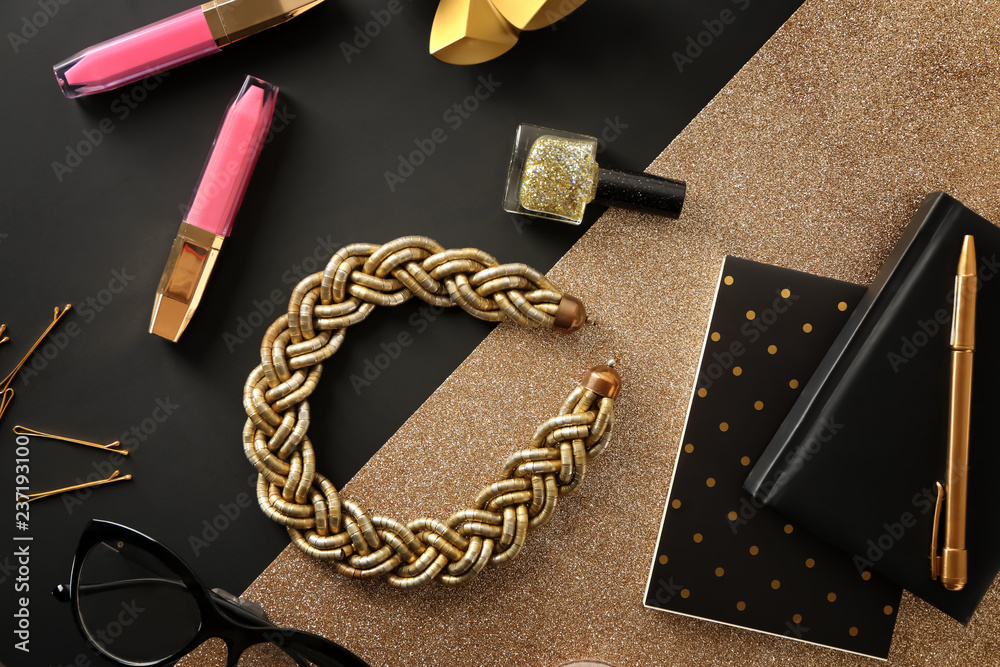 Flat lay composition with cosmetics and accessories on black and golden background