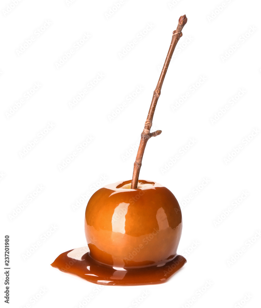 Delicious caramel apple with tree branch on white background