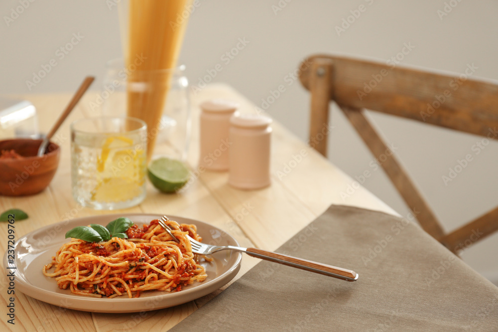 Plate with delicious pasta bolognese on wooden table