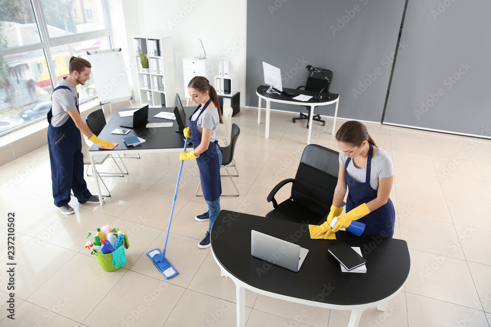 Team of janitors cleaning office