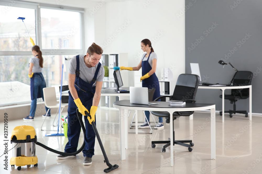 Team of janitors cleaning office