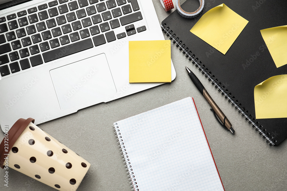 Laptop, notebook and plastic coffee cup on table, top view