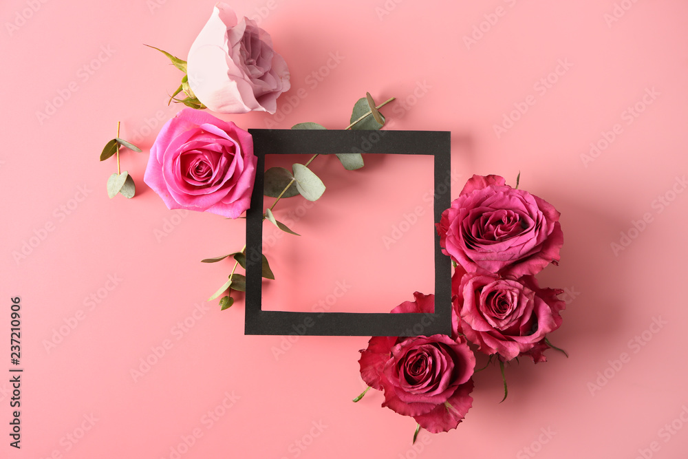 Composition with beautiful roses and frame on color background