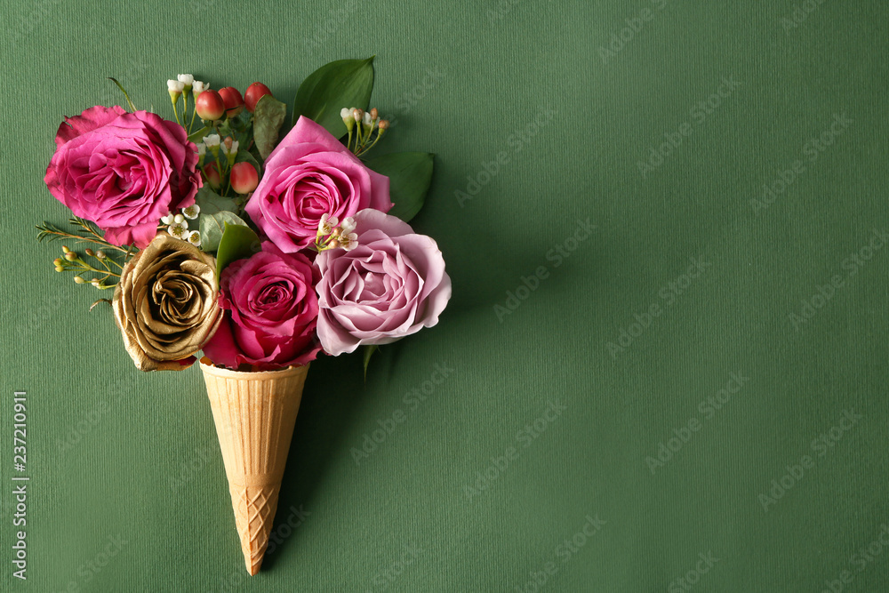 Waffle cone with beautiful roses on color background