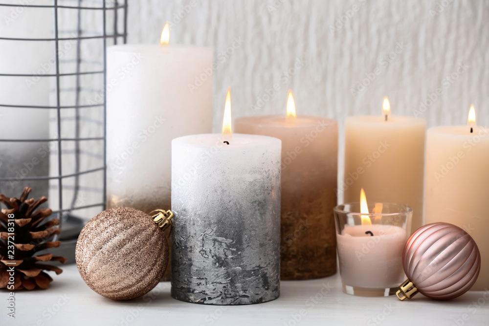 Many burning candles and Christmas decorations on table