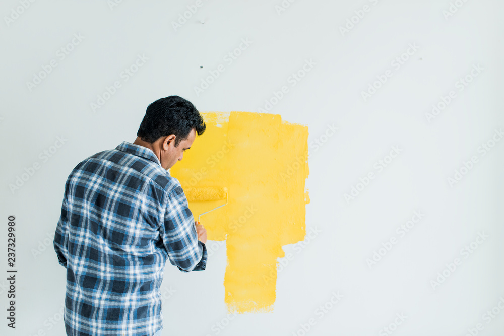 Man painting the walls yellow