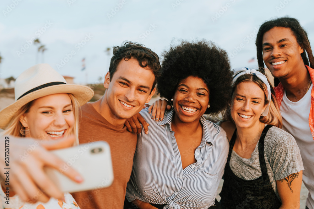 Group of diverse friends taking a selfie at the beach