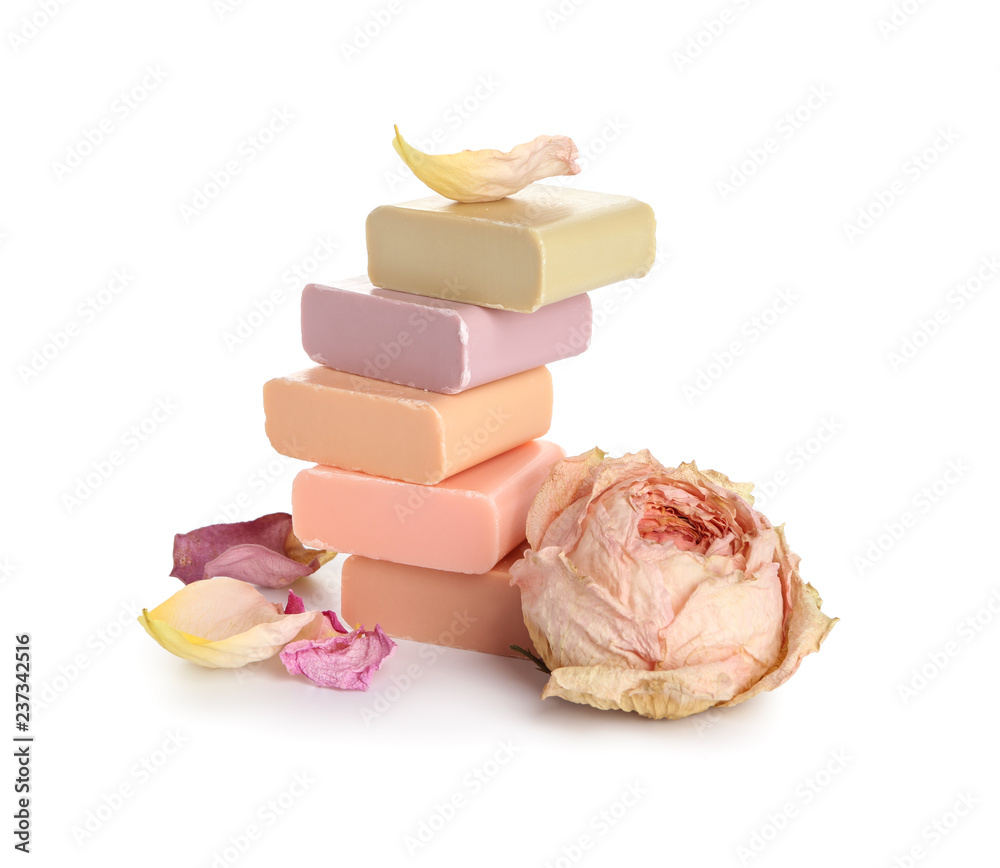 Stack of different soap bars with rose on white background