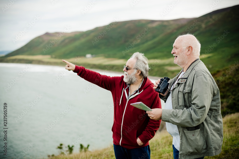 Senior men standing together with a pair of binoculars