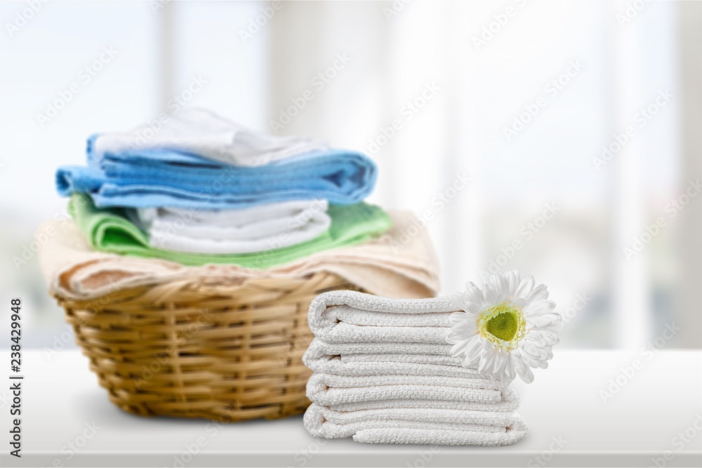 Laundry Basket with colorful towels on background