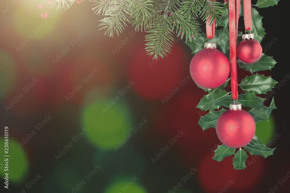 Red Christmas toys weigh on green branch isolated on white