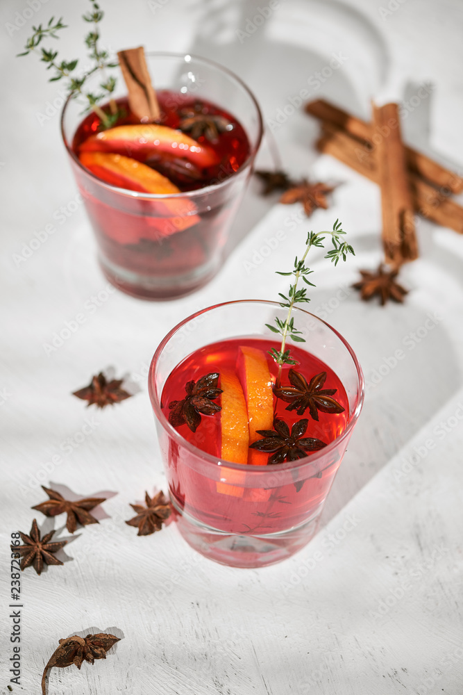 Orange cocktail with rum, liquor, pear slices and thyme on white table, selective focus