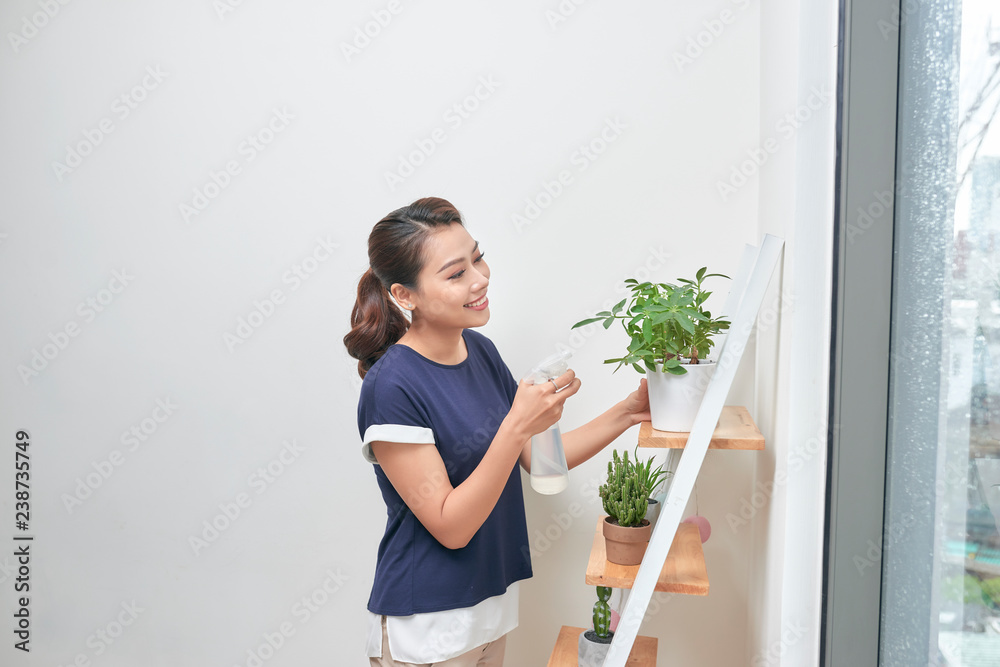 Young Asian women raise the water to plants