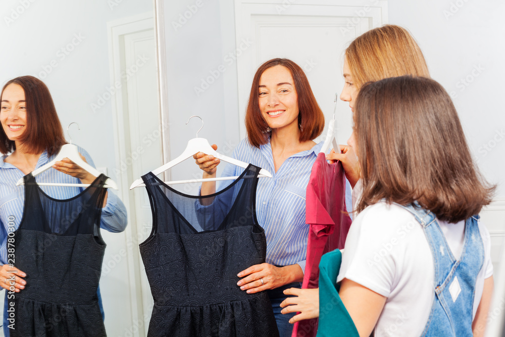 Mother and teenage daughters in evening wear store