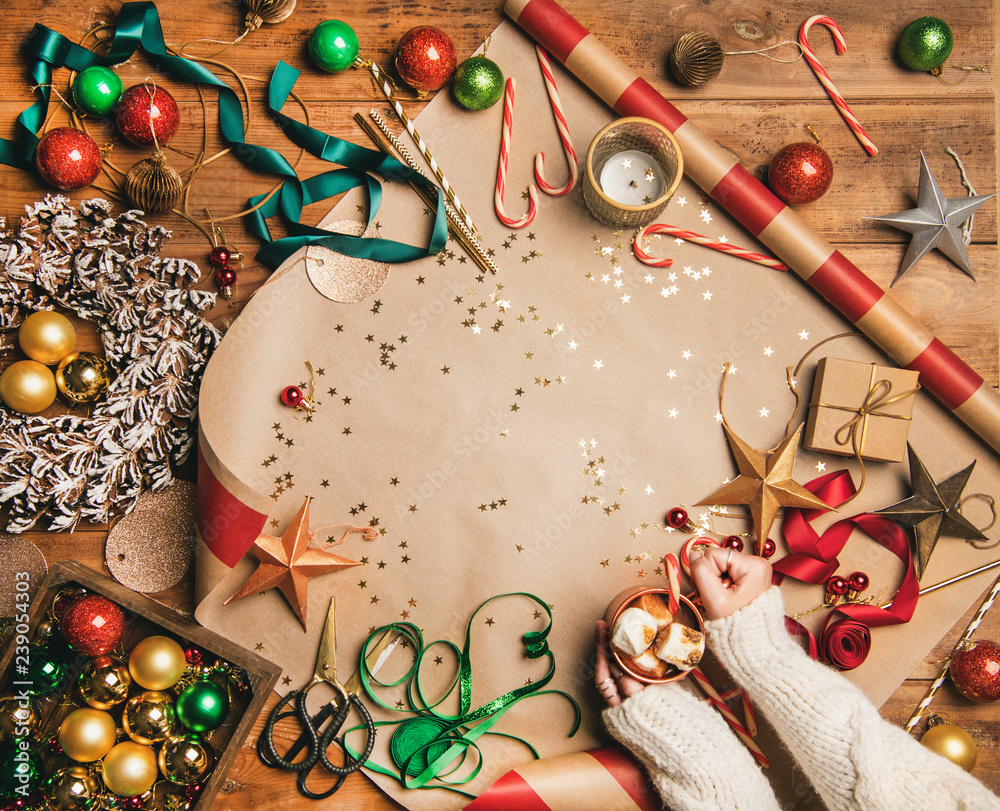 Preparing for New Year. Flat-lay of hot chocolate with marshmallow in womans hands, candy canes, dec