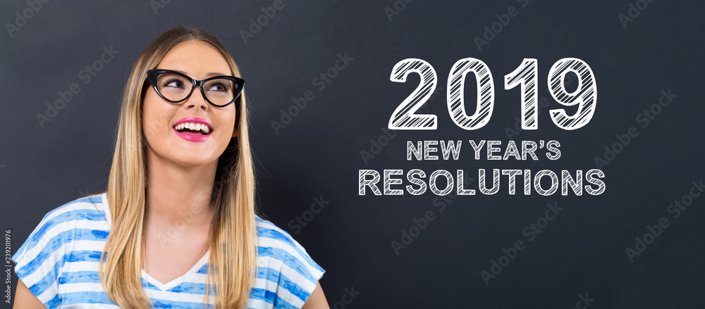 2019 New Years Resolutions with happy young woman in front of a blackboard