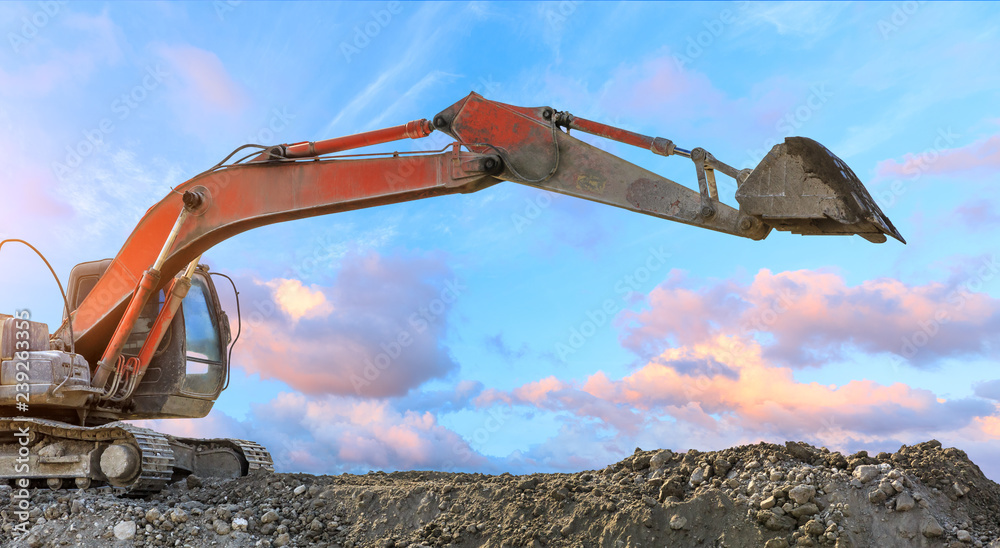 Excavator work on construction site at sunset